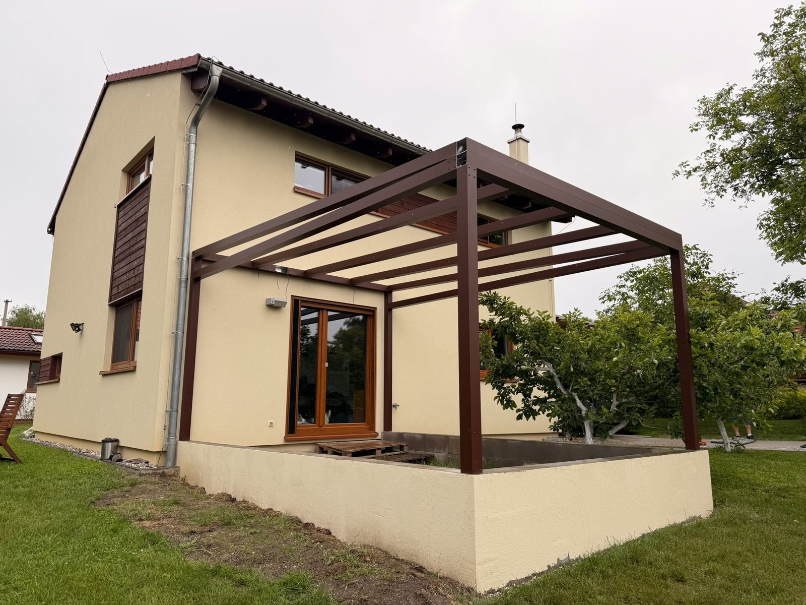 Pergola v dekoru dřeva nad vyvýšenou terasou
